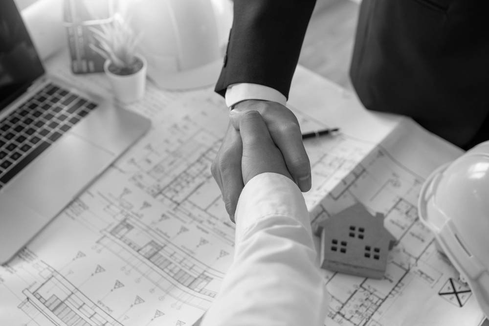 Handshake over architectural plans